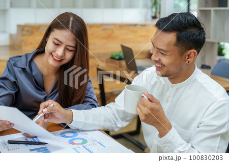 startup business, portrait of two entrepreneurs using computers and financial budget documents to make marketing plans to increase profits. 100830203