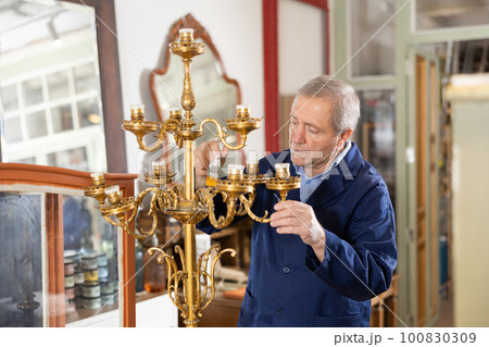 Craftsman restores vintage chandelier in the restoration workshop Craftsman restores vintage chandelier in the restoration workshop 100830309