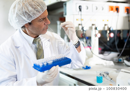 Portrait of an adult male using equipment to work in a laboratory 100830400