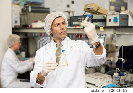 Focused man technician working in research laboratory 100830653