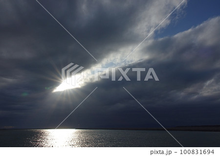 雲間から光が射した夕方の空と反射する港の海・春・広角・空主体・230318pm 雲間から光が射した夕方の空と反射する港の海・春・広角・空主体・230318pm 100831694