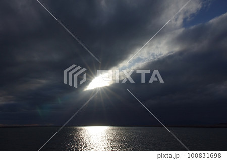 雲間から光が射した夕方の空と反射する港の海・春・広角・空主体・230318pm 雲間から光が射した夕方の空と反射する港の海・春・広角・空主体・230318pm 100831698