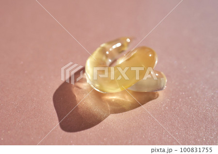 The texture of a yellow transparent gel cosmetic. The texture of a yellow transparent gel cosmetic. 100831755
