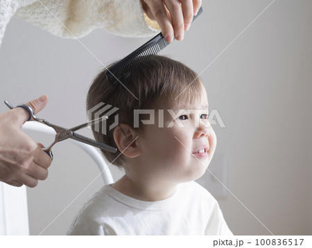 母親に髪を切ってもらう男の子 100836517