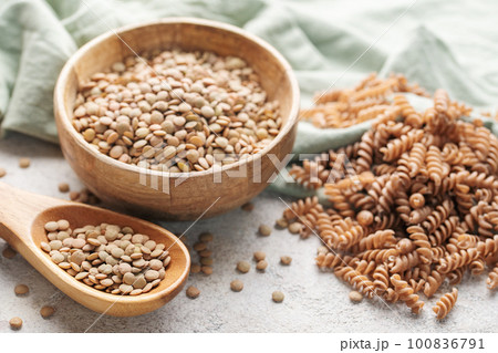 Green lentil fusilli pasta on a gray concrete background. Green lentil fusilli pasta on a gray concrete background. 100836791