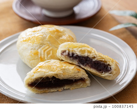 皿の上の半分に割った手作りパイ饅頭と日本茶 100837145