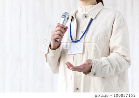 会議・研修中に意見を発表するネームホルダーを付けた私服の女性 会議・研修中に意見を発表するネームホルダーを付けた私服の女性 100837155