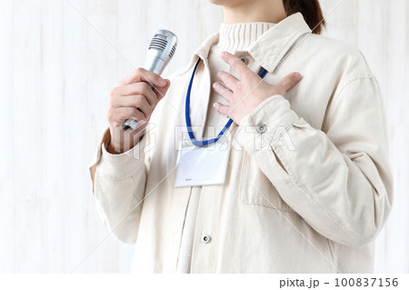 会議・研修中に意見を発表するネームホルダーを付けた私服の女性 100837156