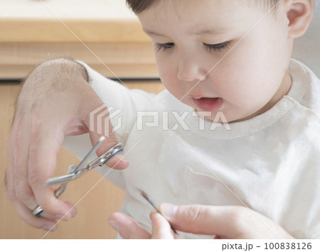 切った髪を見つめる男の子とすきバサミ 切った髪を見つめる男の子とすきバサミ 100838126