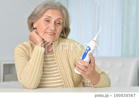 Portrait of a old woman cleaning teeth 100838567
