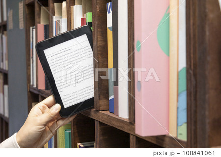 hand selecting, choosing a book 100841061