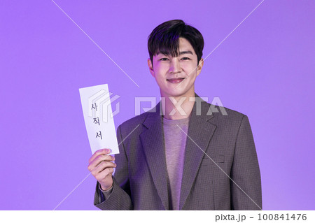 handsome Korean young man holding a letter of resignation handsome Korean young man holding a letter of resignation 100841476