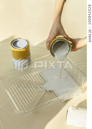 DIY interior hand motion, closeup_pouring paint 100842028