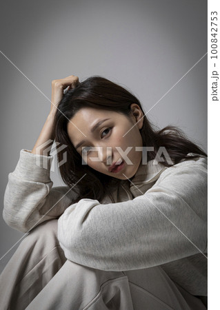 stressed, depressed Korean business woman in pink suit, frustrated 100842753