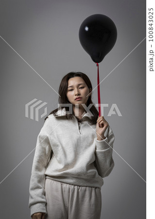 stressed, depressed Korean business woman in pink suit, worrying 100843025
