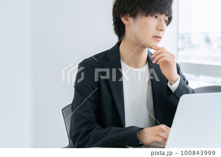 オフィスでパソコンに向かう若いビジネスマン 100843999