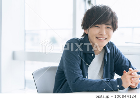 窓際で微笑む若い男性 100844124