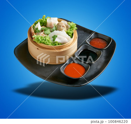 Floating Dim Sum in Bamboo Basket on blue gradient Floating Dim Sum in Bamboo Basket on blue gradient 100846220