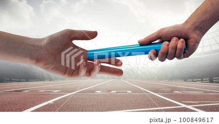 Image of athlete's hands passing relay baton over racing track in sports stadium Image of athlete's hands passing relay baton over racing track in sports stadium 100849617