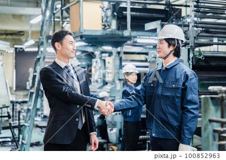 取引先と握手をする工場のスタッフ 100852963