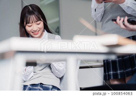 教室でスマホを見ながら話す女子高生 教室でスマホを見ながら話す女子高生 100854063