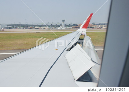 wing on commercial plane take off from airport in Japan wing on commercial plane take off from airport in Japan 100854295