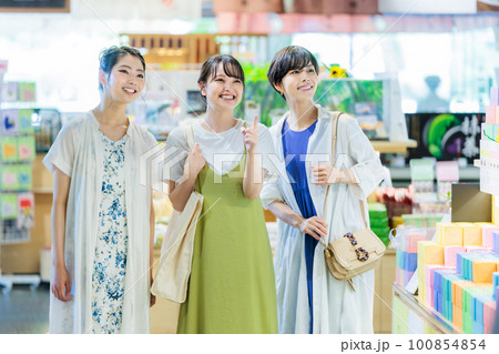 女子旅で楽しくお土産を選ぶ若い女性 女子旅で楽しくお土産を選ぶ若い女性 100854854