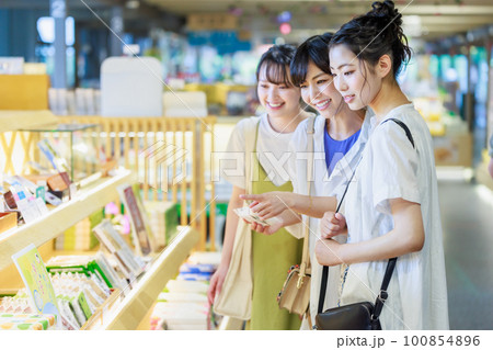 女子旅で楽しくお土産を選ぶ若い女性 100854896