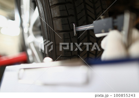 Visiting tire shop and assessing car tire damage 100855243