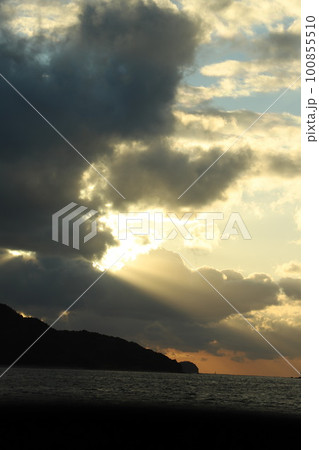 海に沈む夕日　雲の隙間から差し込む光 100855510