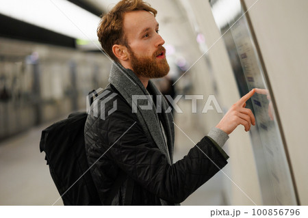 Bearded man looks at a subway train map Bearded man looks at a subway train map 100856796