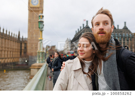 Couple stands in an embrace near Big Ben in London 100858262