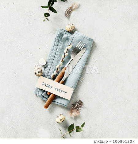Easter table setting with fork, knife, linen napkin, eggs and feathers flat lay Easter table setting with fork, knife, linen napkin, eggs and feathers flat lay 100861207