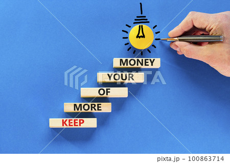 Keep more of your money symbol. Concept words Keep more of your money on wooden block. Beautiful blue table blue background. Businessman hand. Business keep more of your money concept. Copy space. 100863714