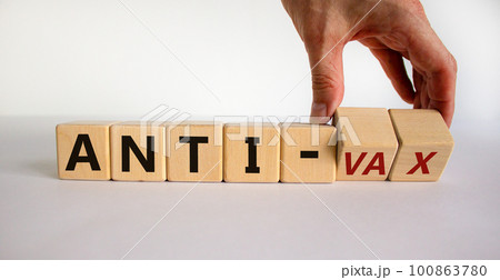 Anti-vax symbol. Doctor turns cubes with words 'anti-vax'. Beautiful white background. Copy space. Business, medical covid-19 vaccination or anti-vax concept. 100863780