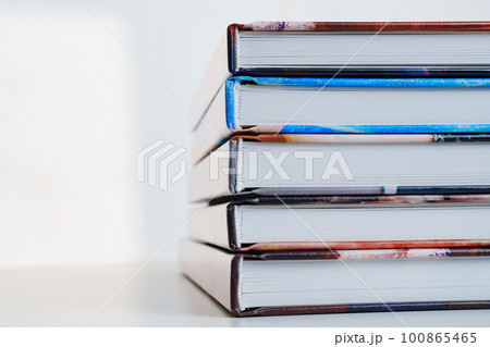 photobooks stacked on top of each other on a white table. 100865465