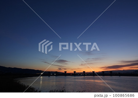朝焼け空のグラデーションと反射する川・春・230301am 100865686