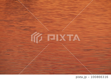 赤く朝焼けした雲が映り込んだ川面・春・230301am 100866316