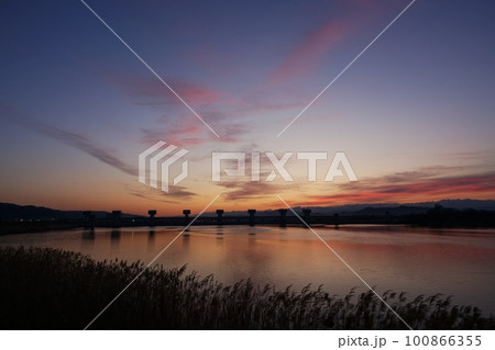 赤く朝焼けした空と映り込む川・春・230301am 100866355