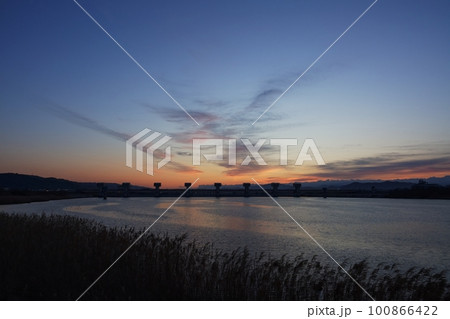 多彩に朝焼けした空と映り込む川・春・230301am 100866422