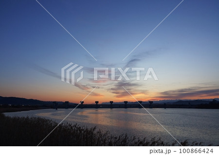 多彩に朝焼けした空と映り込む川・春・230301am 100866424