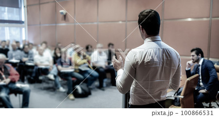 Speaker at Business Conference with Public Presentations. Audience at the conference hall. Entrepreneurship club. Rear view. Horisontal composition. Background blur. Speaker at Business Conference with Public Presentations. Audience at the conference hall. Entrepreneurship club. Rear view. Horisontal composition. Background blur. 100866531
