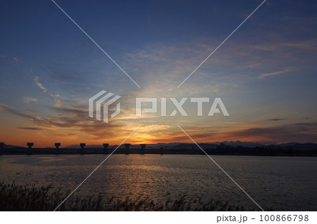 多彩に朝焼けした空と映り込む川・春・230301am 100866798