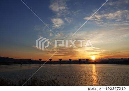 朝焼けと朝陽が映り込む川面・春・230301am 100867219