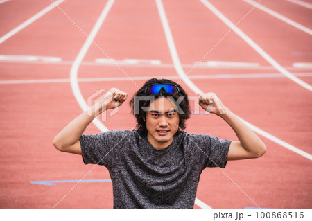 陸上競技のトラックでガッツポーズをする男性ランナー 陸上競技のトラックでガッツポーズをする男性ランナー 100868516
