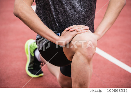 陸上競技のトラックでストレッチをするランナー 100868532