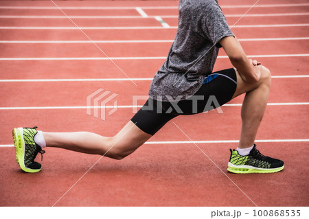 陸上競技のトラックでストレッチをするランナー 100868535