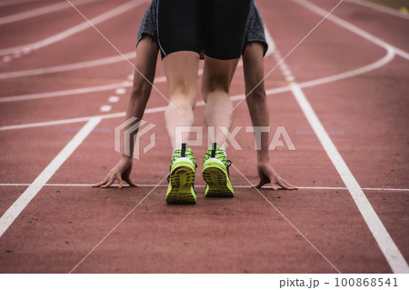 陸上競技場のトラックでスタートラインにつくランナー 100868541