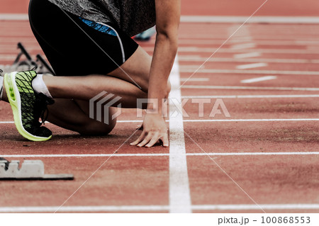 陸上競技場のトラックでスタートラインにつくランナー 100868553