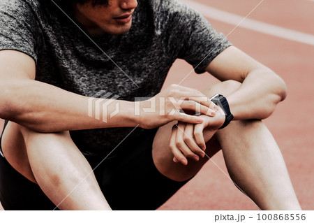 スマートウォッチを確認する男性ランナー スマートウォッチを確認する男性ランナー 100868556
